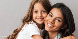 Mom and Daughter Embracing with Nice White Smiles
